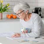 Elderly Woman At Home Holds Euro Money