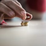 Closeup of male senior hands stacking Euro coins
