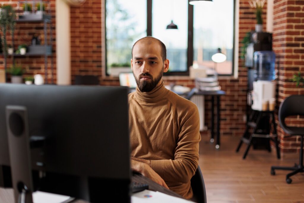 Business company entrepreneur thinking about financial solutions while sitting at desk in office