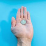 A man holds one coin in his palm, close-up. Two euros in hand, POV. Bankruptcy, poverty, falling